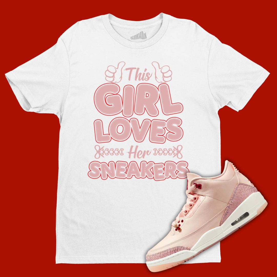 White 'This Girl Loves Her Sneakers' t-shirt designed to match the Air Jordan 3 Valentine's Day 2025, featuring bold typography and sneaker-inspired graphics.